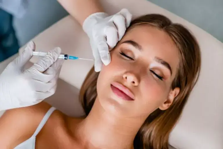 Administering Sculptra injection to a client's cheek.