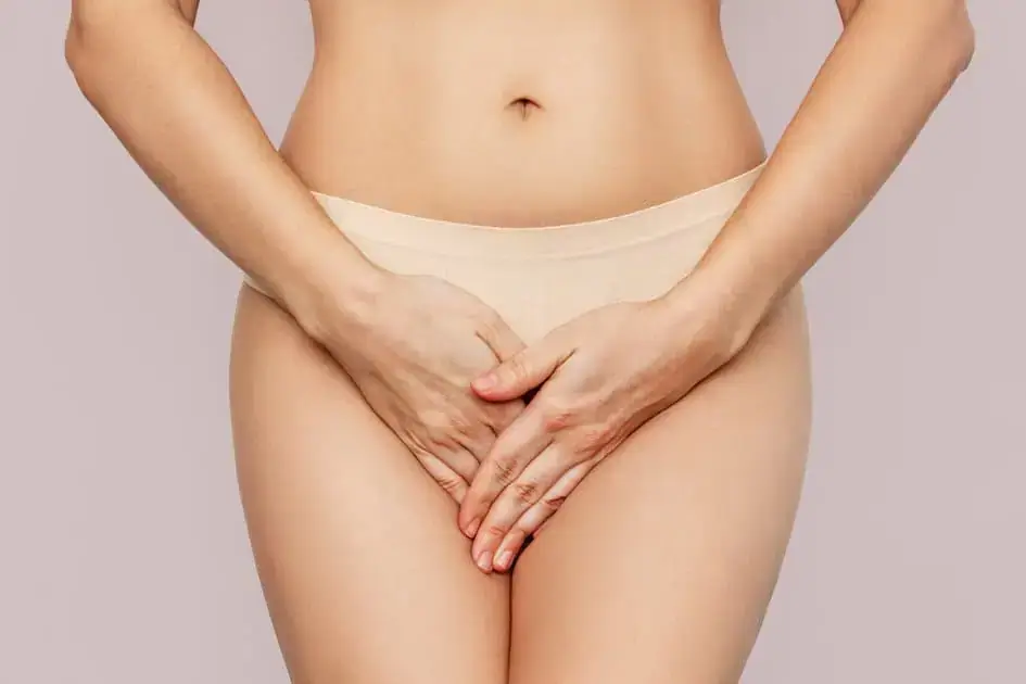 Woman holding her lower abdomen, representing urinary incontinence treatment in Tulsa, OK for improved bladder control and pelvic floor health.